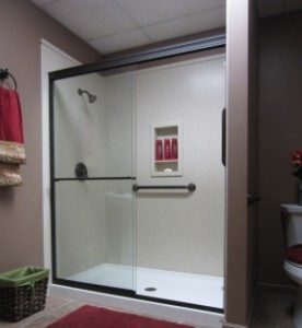 A walk-in shower enclosure with a safety grab bar
