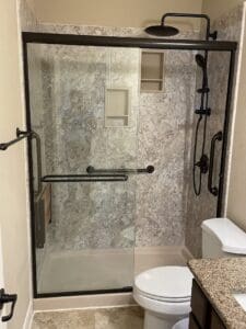 Black framed walk-in shower in small bathroom
